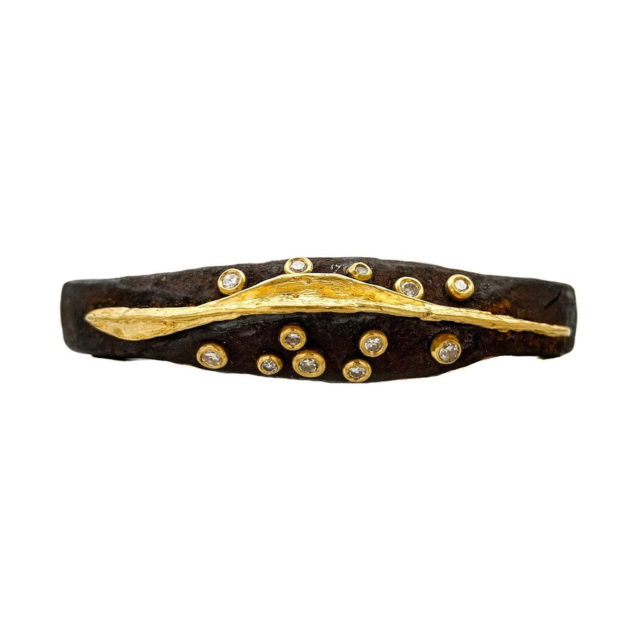 12 diamonds set in 22K gold bezels and randomly scattered on either side of a sculpted 22K line set in the center of an old African wrought iron medicine bracelet