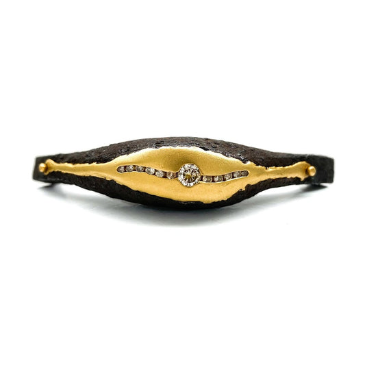 12 diamonds set into a puddle of 22K gold and riveted into the opening of an old African wrought iron Medicine bracelet
