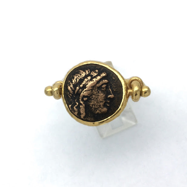 Sturup ring featuring an ancient bronze Greek coin with the head of Apollo, set in a way that allows the coin to rotate so that coin can be worn with either side showing