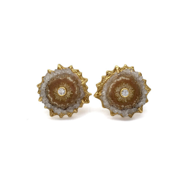 Cross section slice of an citrine crystalized stiglatite with faceted bezel set white sapphire at the center