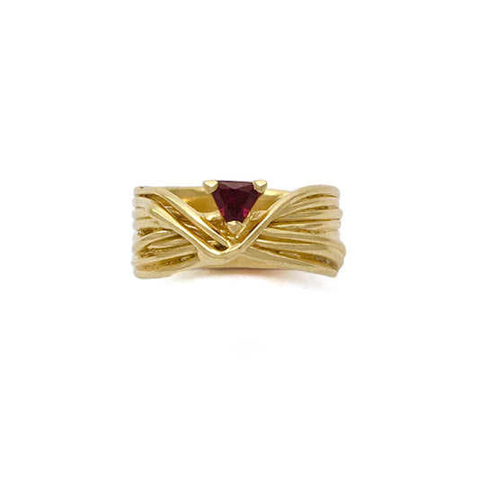 Criss crossed golden cords set with a deep red garnet