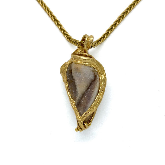Fossilized sea shell with a Druzy surface set in 18K gold. Druzy is a natural surface of tiny crystals that sparkle like dew on a morning meadow.