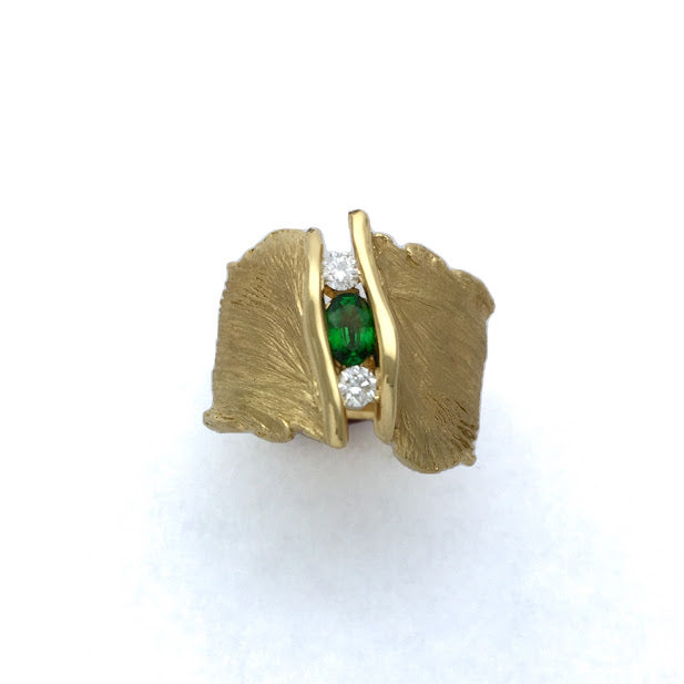 Oval Tsavorite Garnet and two Diamonds set into the cavity of a feather texture ring