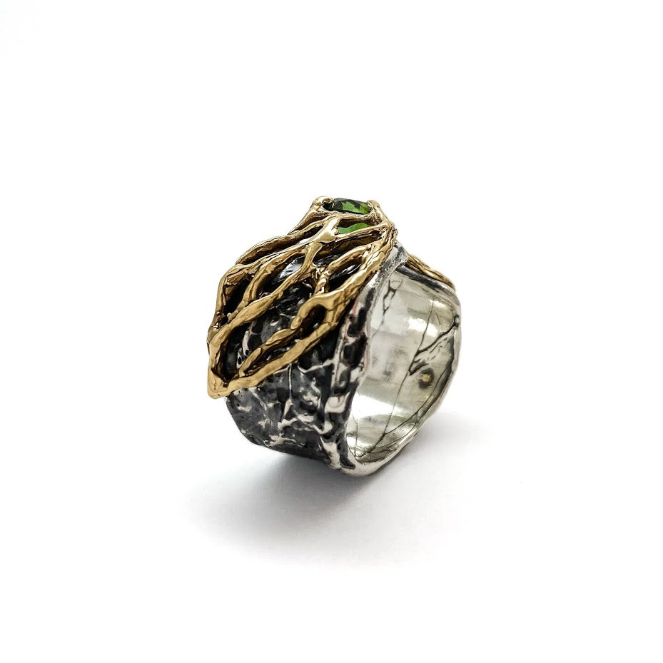 Gold lace over fluid silver band set with a green tourmaline