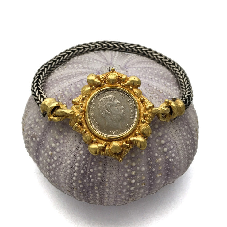 Hawaiian dime from 1883 surrounded by 22K sea shells and caviar