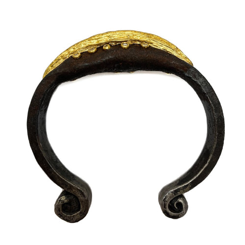 12 diamonds set in 22K gold bezels and randomly scattered on either side of a sculpted 22K line set in the center of an old African wrought iron medicine bracelet