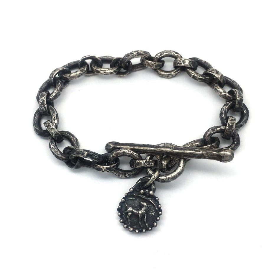 Bracelet composed of heavily textured oval links with a single dangling charm featuring a lion image from an impression of an ancient Roman stone seal