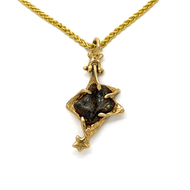 Star shaped pendant set with an Odessa Texas Meteorite and accented with gold stars