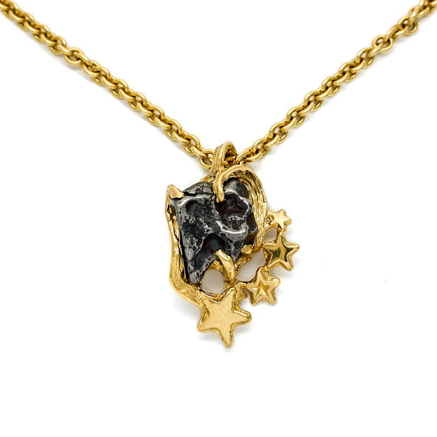 Heart shaped pendant set with an Odessa Texas Meteorite and accented with gold stars