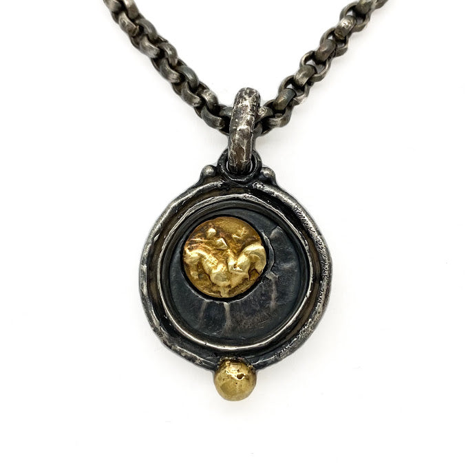 Replica of an ancient Greek silver coin. A modern day gold and silver transposition of Taras seated on a dolphin