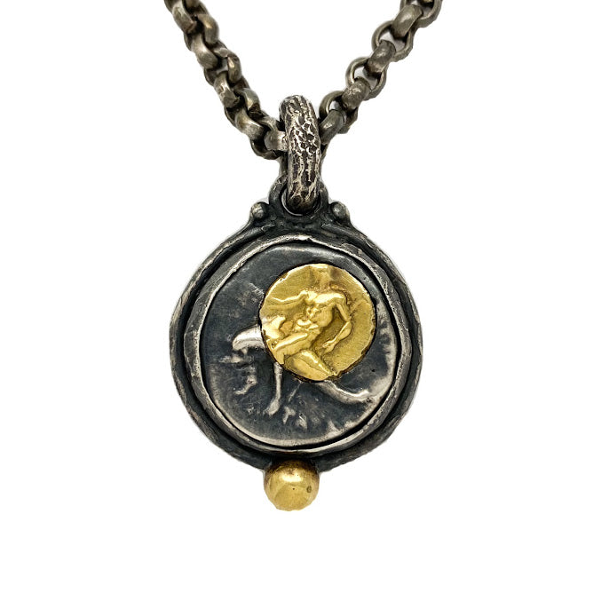 Replica of an ancient Greek silver coin. A modern day gold and silver transposition of Taras seated on a dolphin