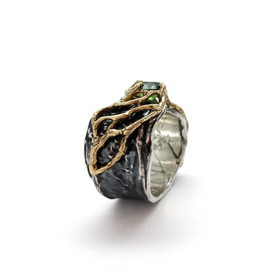 Gold lace over fluid silver band set with a green tourmaline